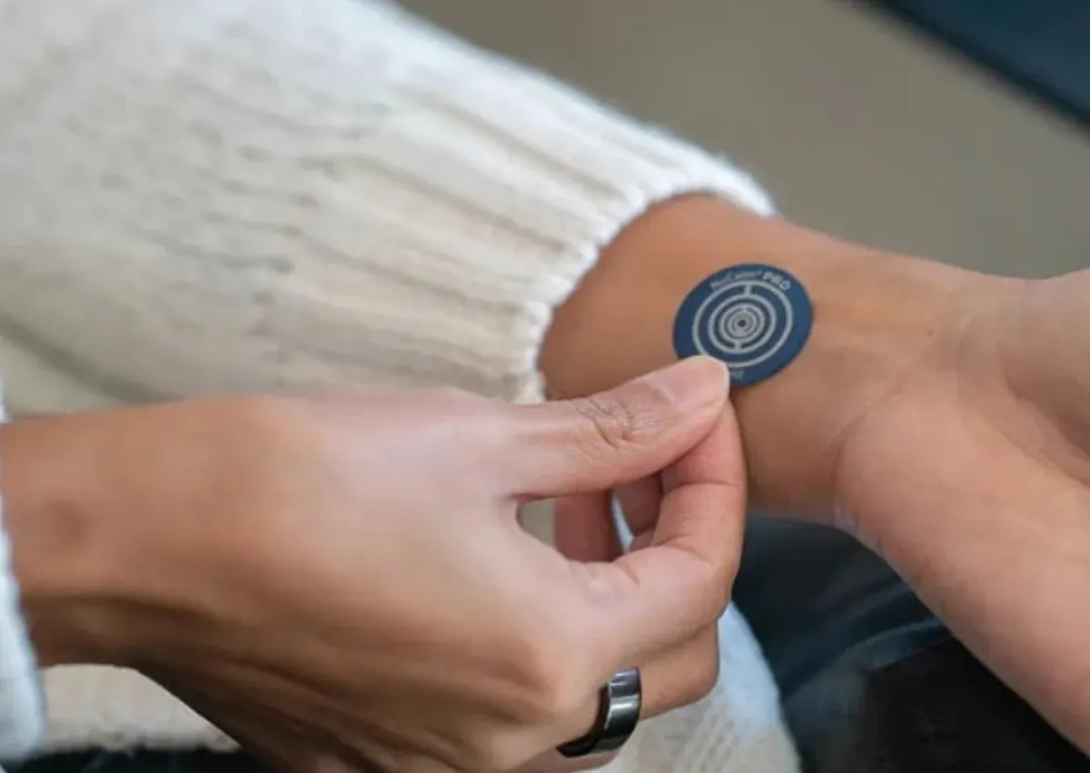 A NuCalm biosignal processing disc being applied to the Pericardium 6 acupressure point on the inside of the left wrist