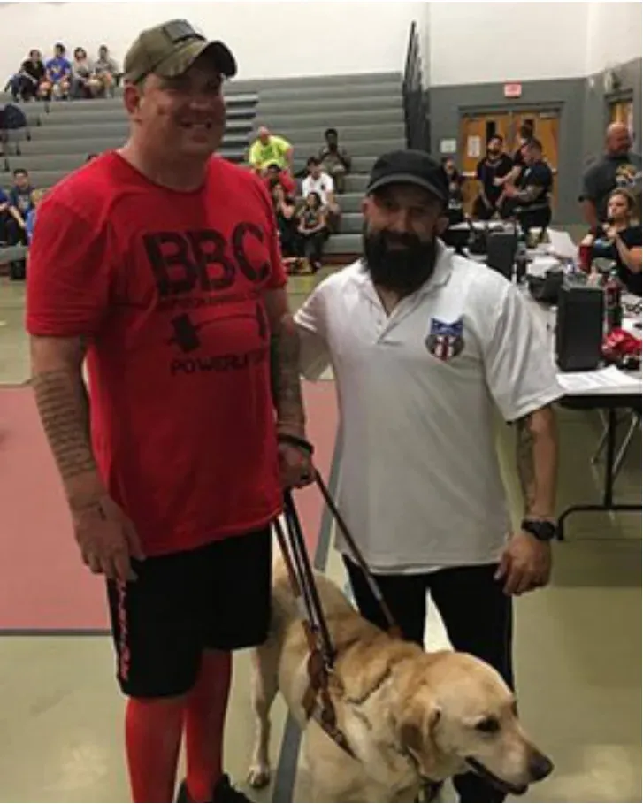 Two men standing with a service dog