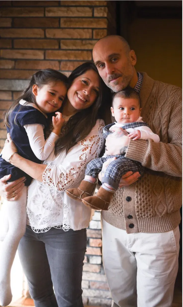 A family portrait of two parents with a toddler and a baby