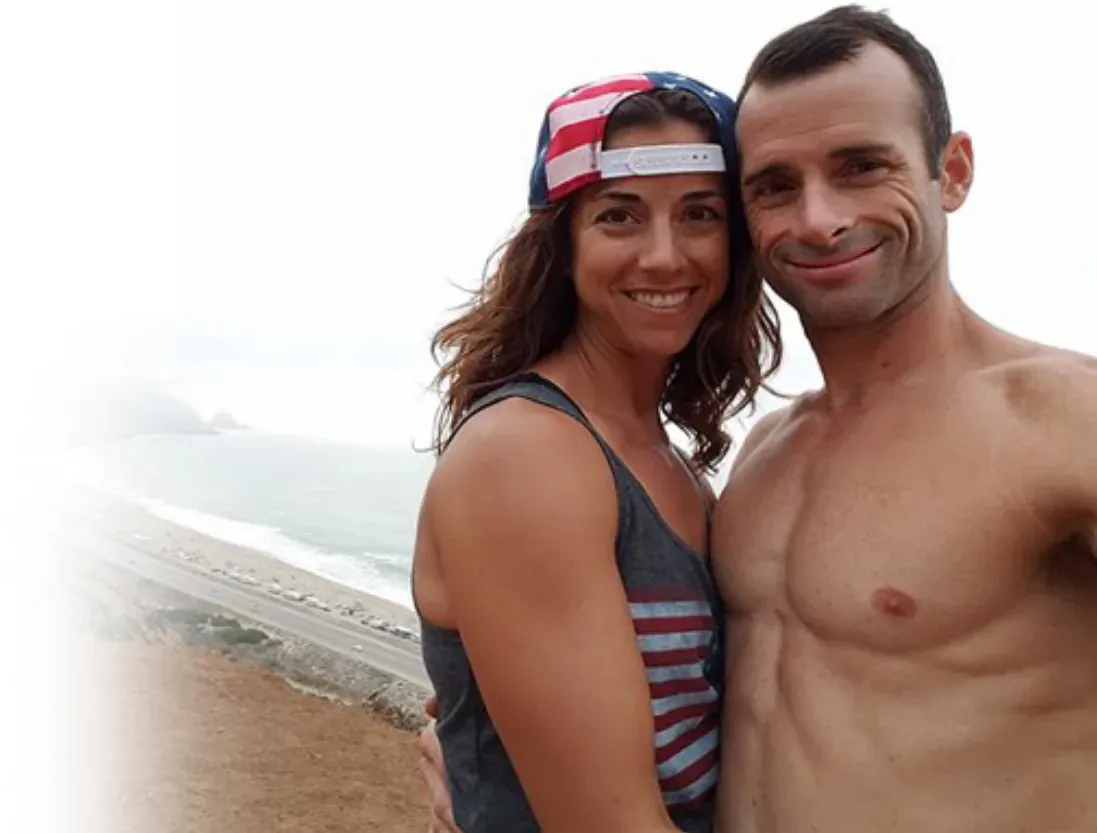 Ken and his wife smiling on a beach
