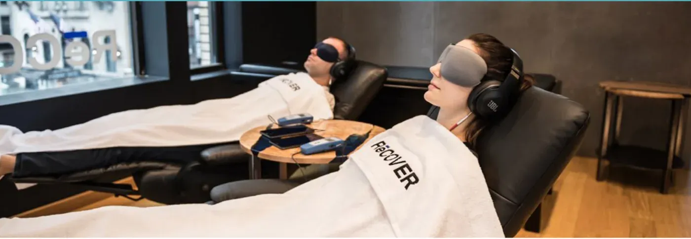 Clients resting in recliners with NuCalm eye masks at RēCOVER