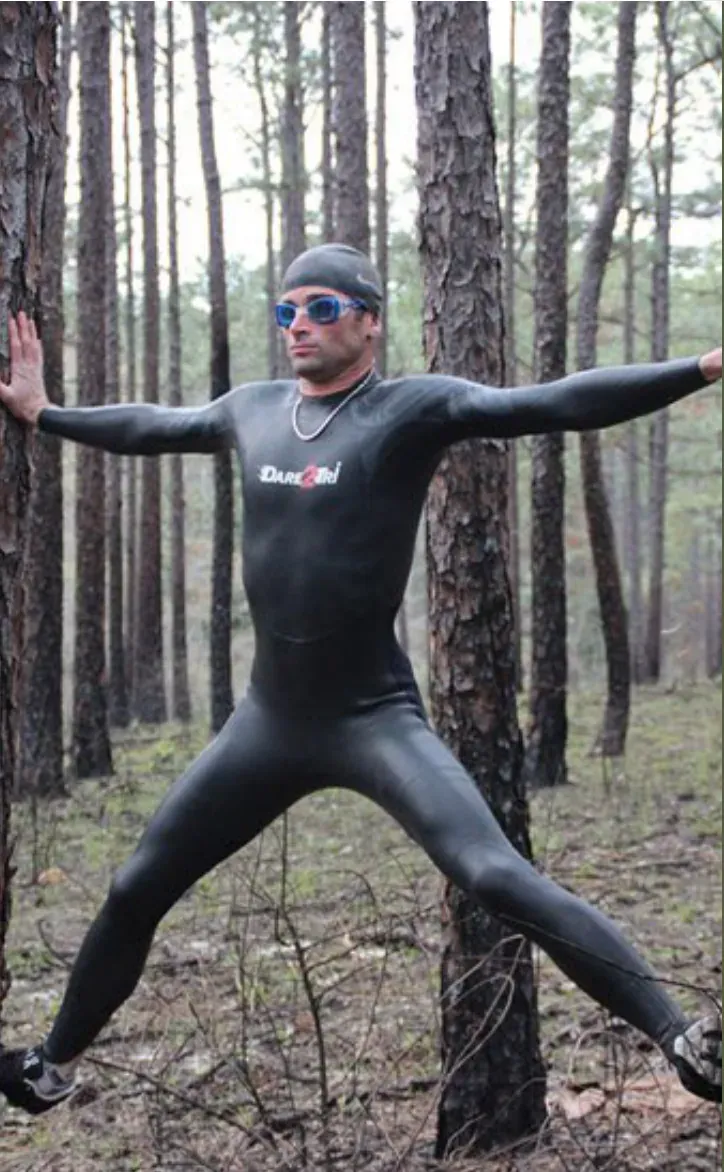 Ken stretching in a wetsuit in a forest