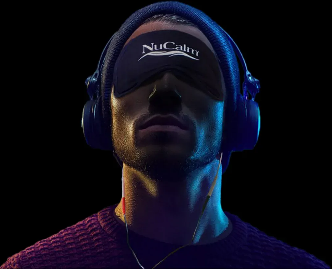 A man wearing a NuCalm eye mask pushed up on his forehead and headphones