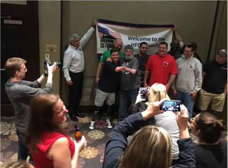 A crowd gathered around Blake at a welcome event