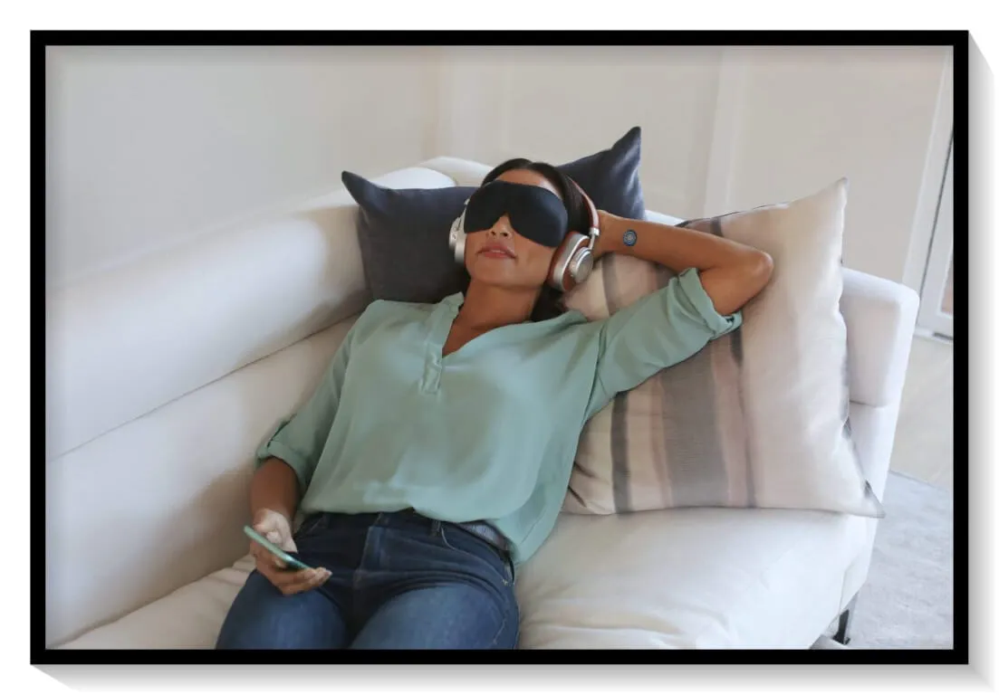 Woman lying on a couch listening to NuCalm