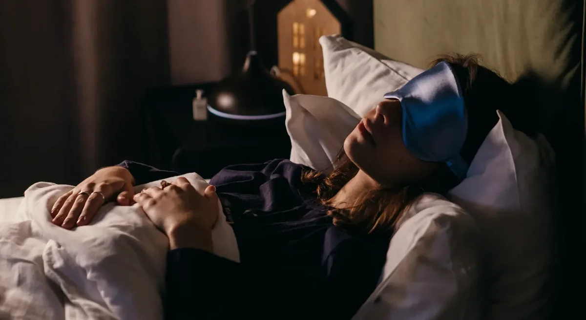 Person sleeping soundly wearing a NuCalm eye mask